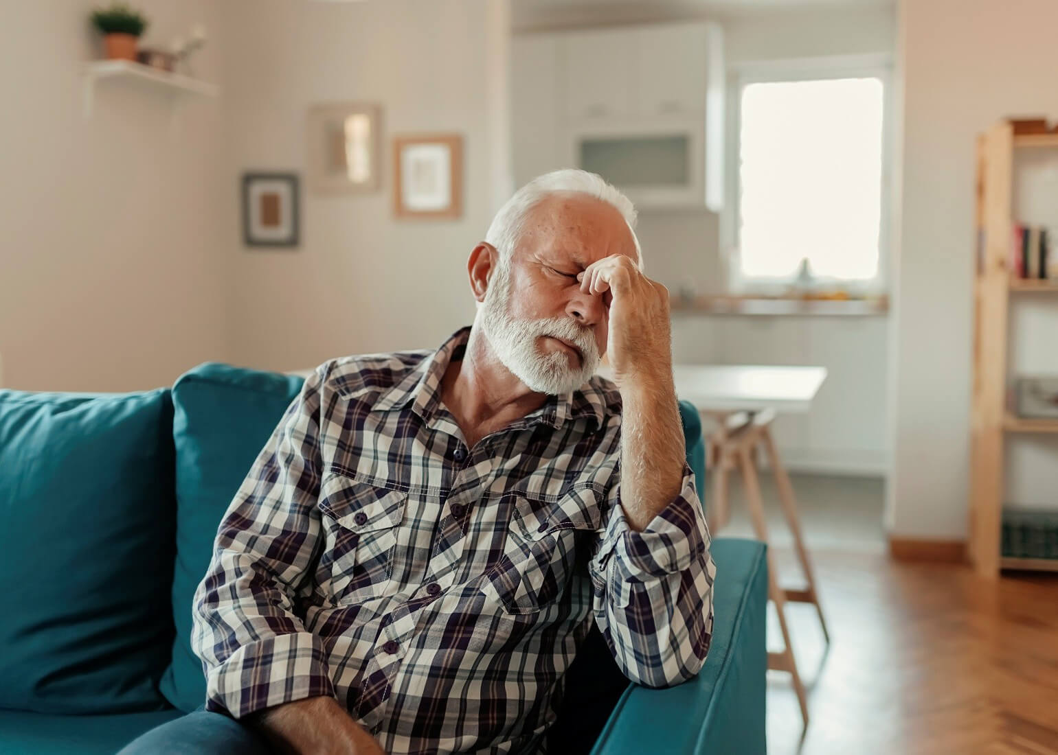 A man with his hand to his face and eyes closed, indicating fatigue. Sleep studies for sleep apnea are available at Astera Health in Wadena, MN.