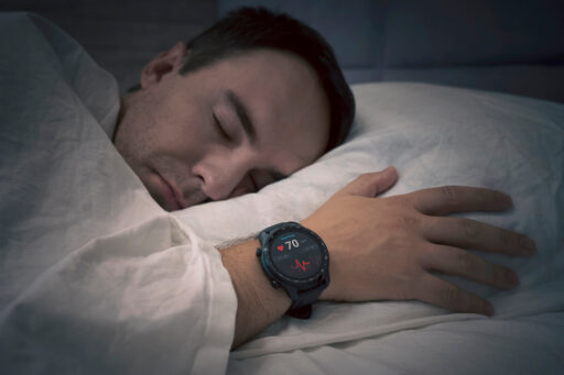 A man sleeps with a wrist monitor logging vitals. Sleep apnea can affect heart health and cause day-to-day fatigue, making sleep studies at Astera Health in Wadena, MN, an important step toward better health.